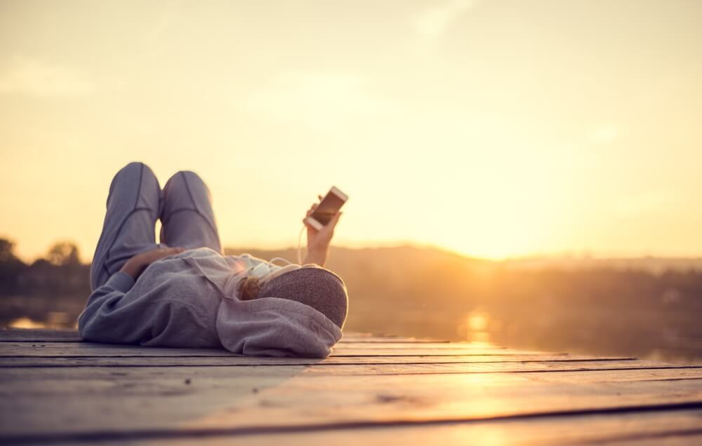 Person med mobil i solnedgang