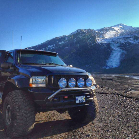 En enorm Super Jeep parkert foran vulkan på Island