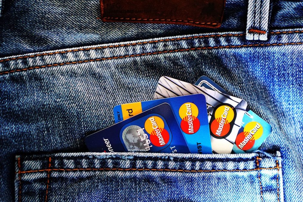 Flere kredittkort ligger i baklommen på en bukse