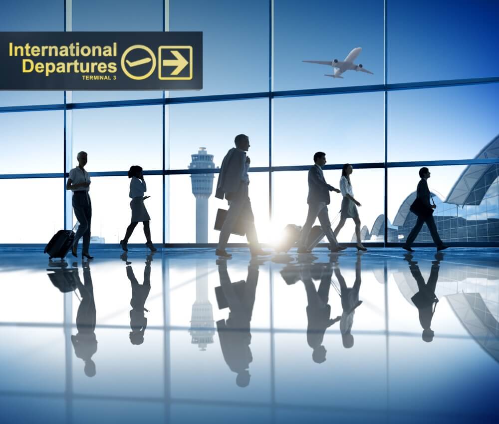 Mennesker med små kofferter beveger seg på en flyplass. Foto