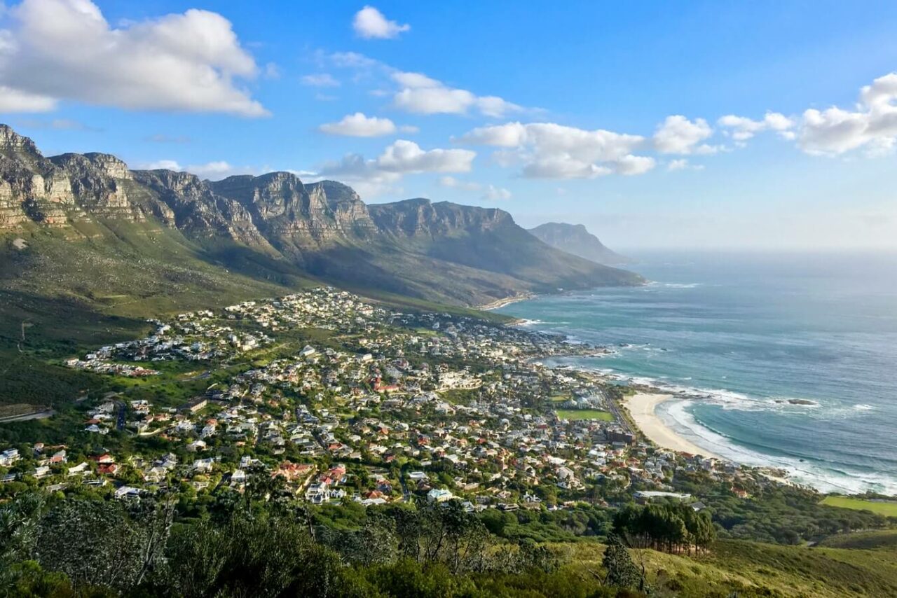 Utsiktsbilde over Cape Town, hvor du ser masse hus ligge nedover en bakke mot havet. Foto