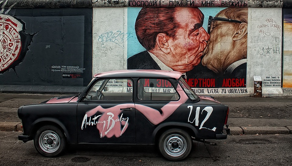 Gatekunst av to menn som kysser på Berlinmuren. Foto