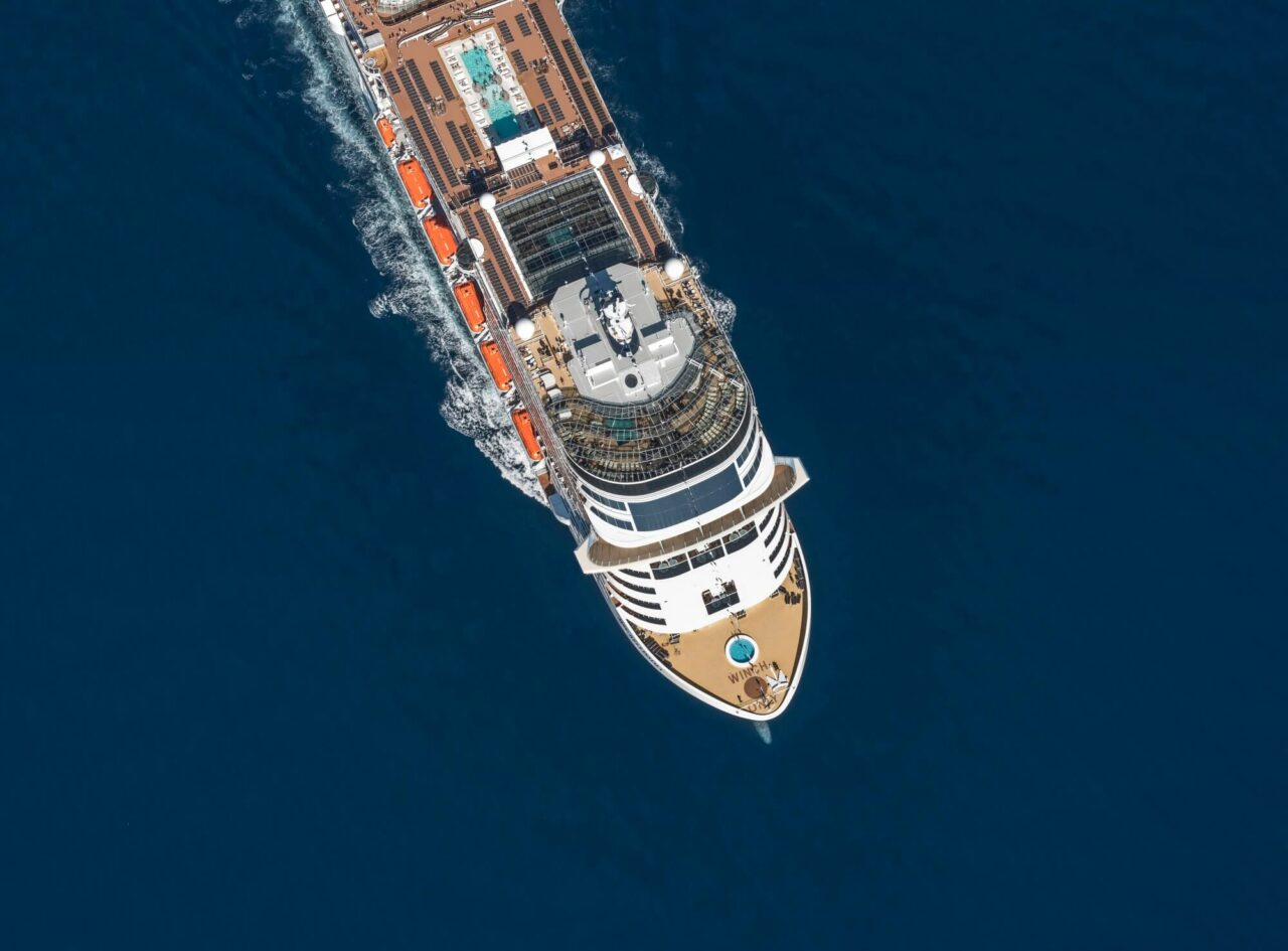 Et cruiseskip som seiler på åpent hav sett ovenfra 