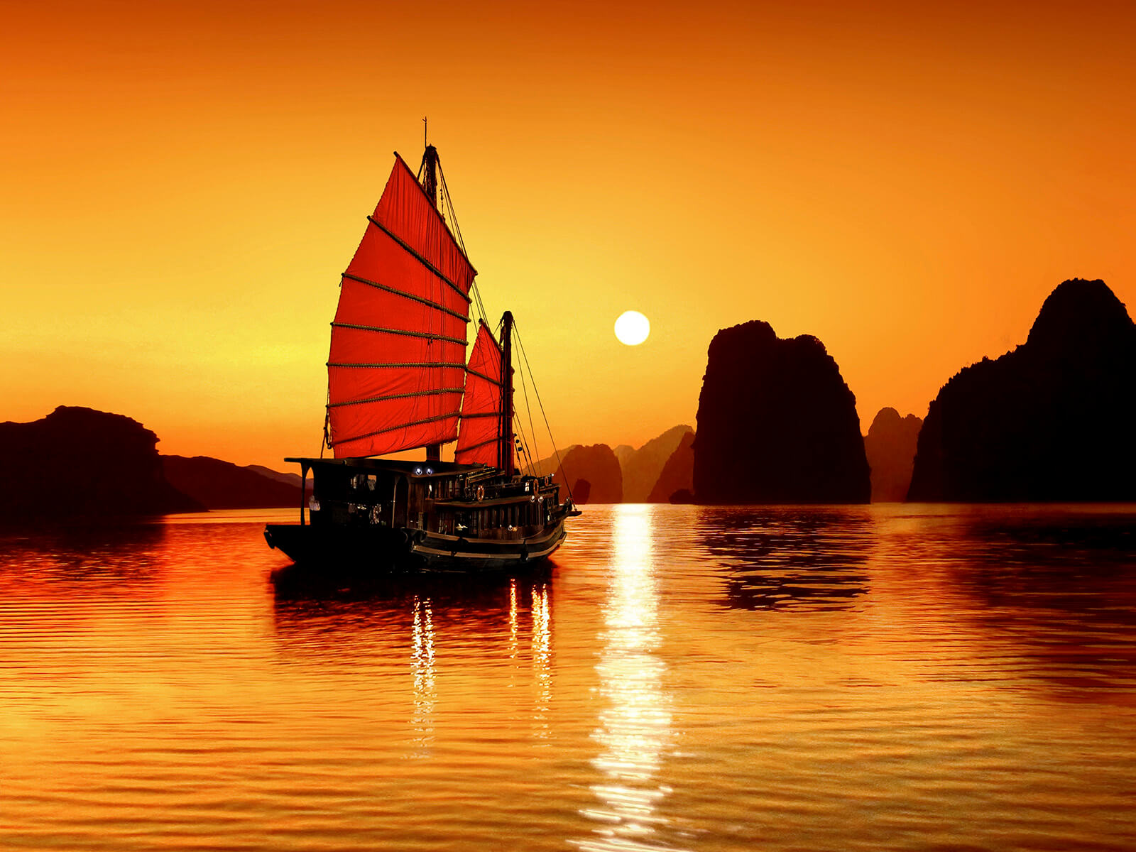 Tradisjonell båt i solnedgang i Halong Bay, Vietnam. Foto.