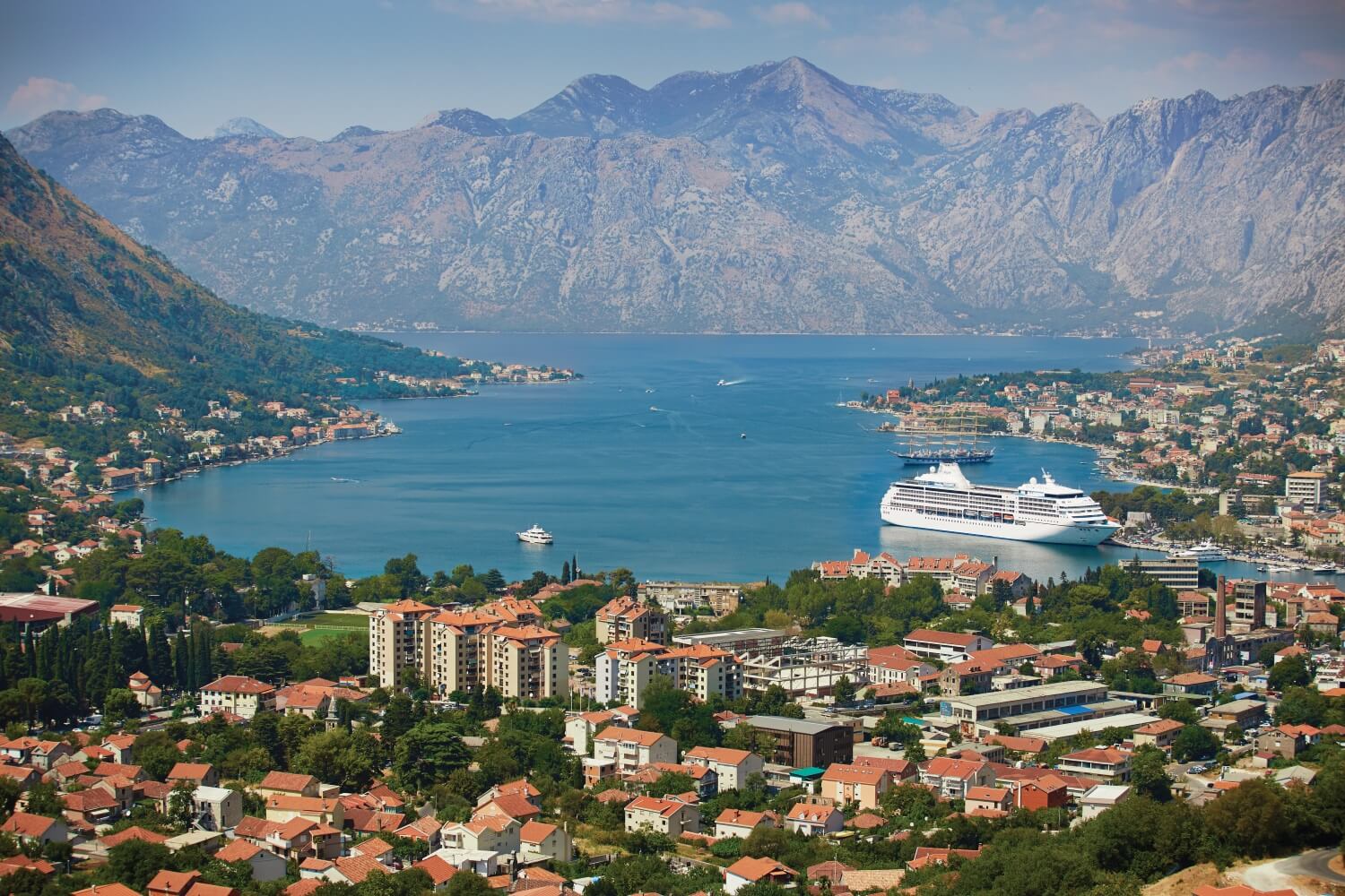 Et Regent-cruiseskip ligger til kai i Kotor, Montenegro. Bildet tatt fra en høyde i utkanten av byen. Foto.