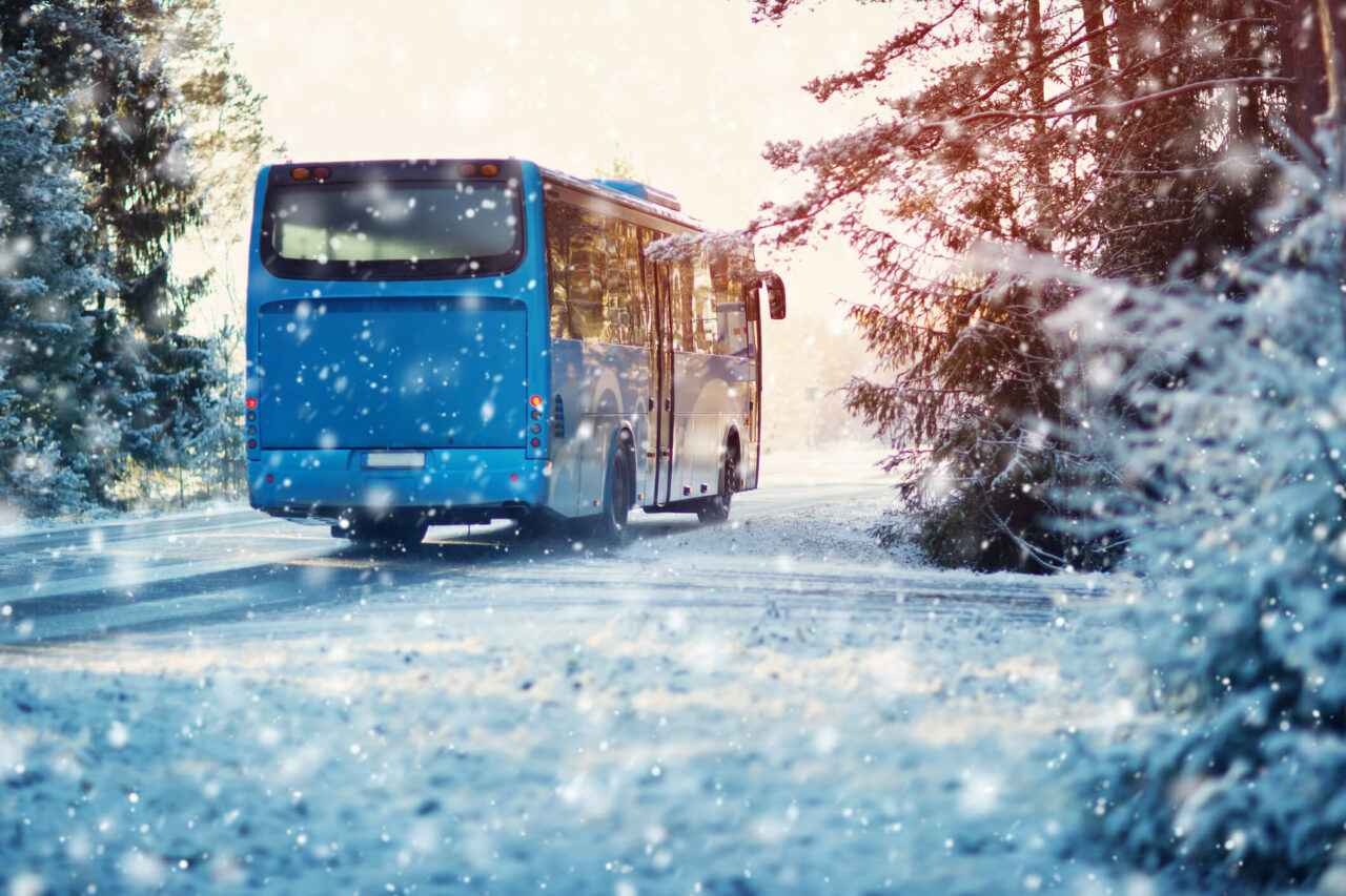 Blå buss i vinterlandskap