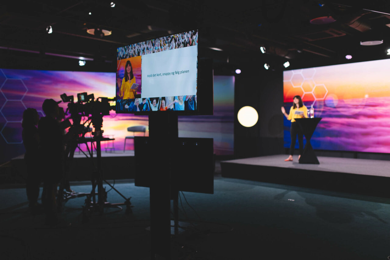 Digitalt arrangement i studio med programleder på scenen