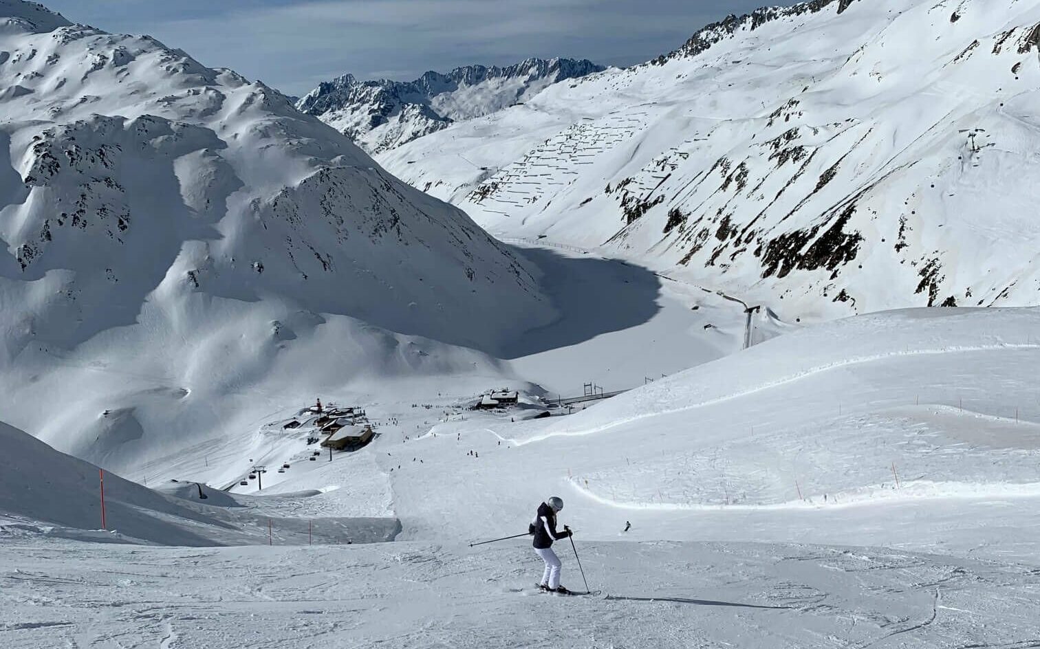 Snøkledd alpinbakke med utsikt til fjell