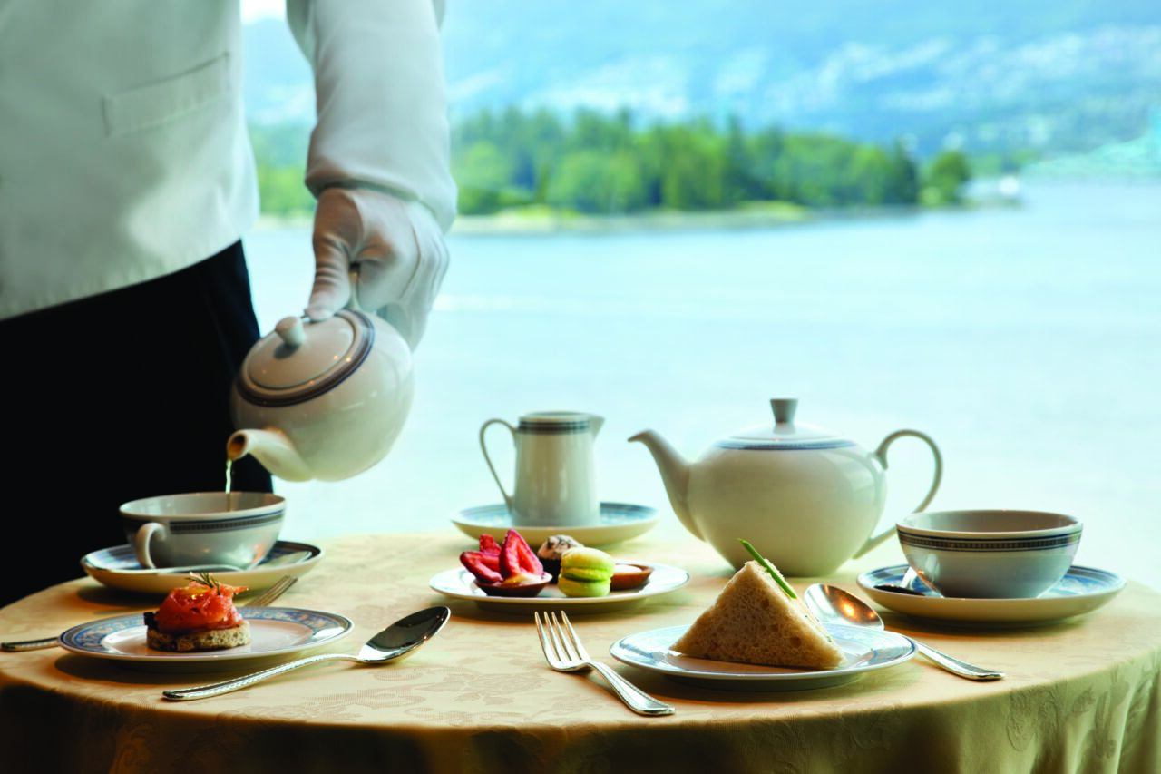 Afternoon Tea i Horizons Lounge, Oceania Cruises. En kelner skjenker te i en kopp. Foto.