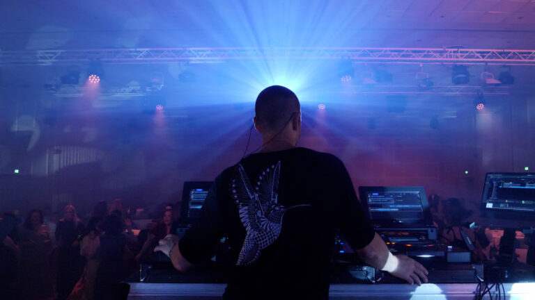 DJ står og spiller musikk foran dansegulvet