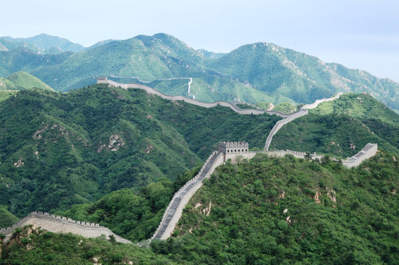 Den kinesiske mur slynger seg mellom åser og grønne skoger
