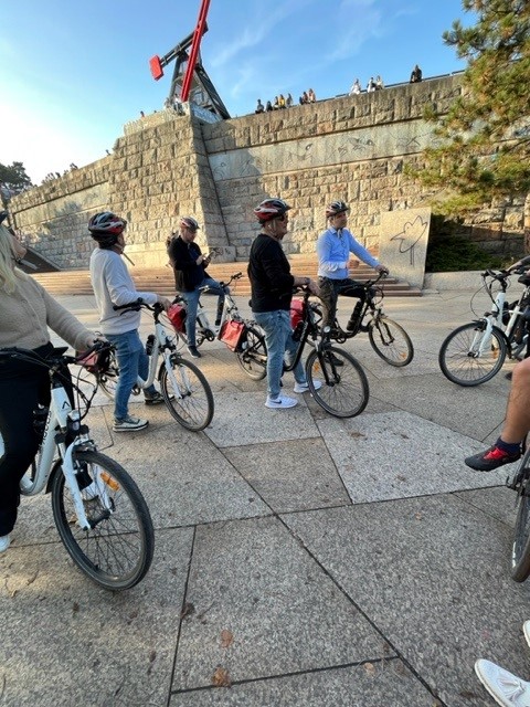 Mennesker står med sykler klare for en sykkeltur. Foto