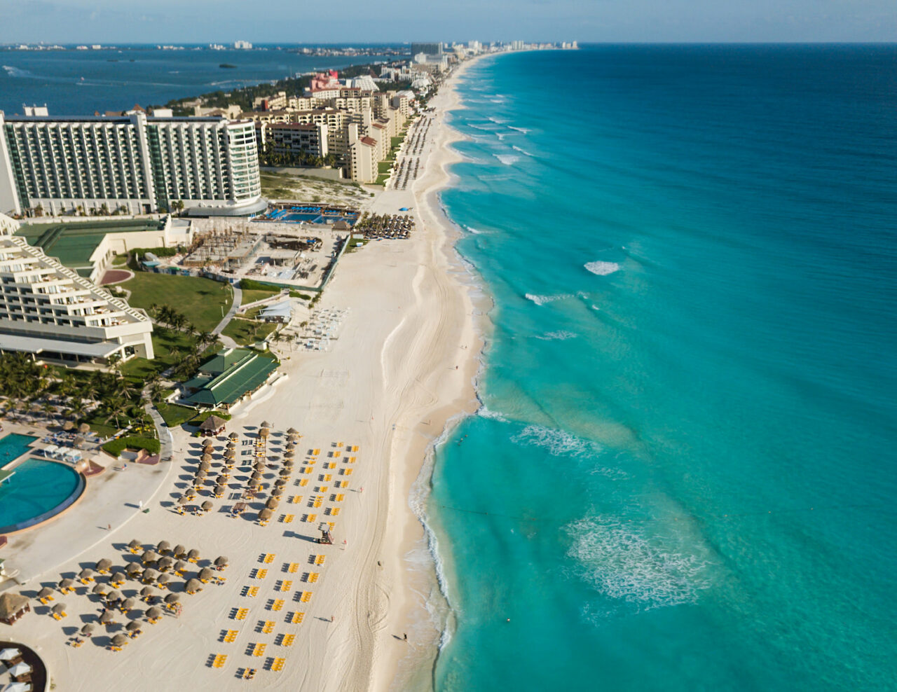 Oversiktsbilde av en strand med flere hoteller og aktiviteter. Foto