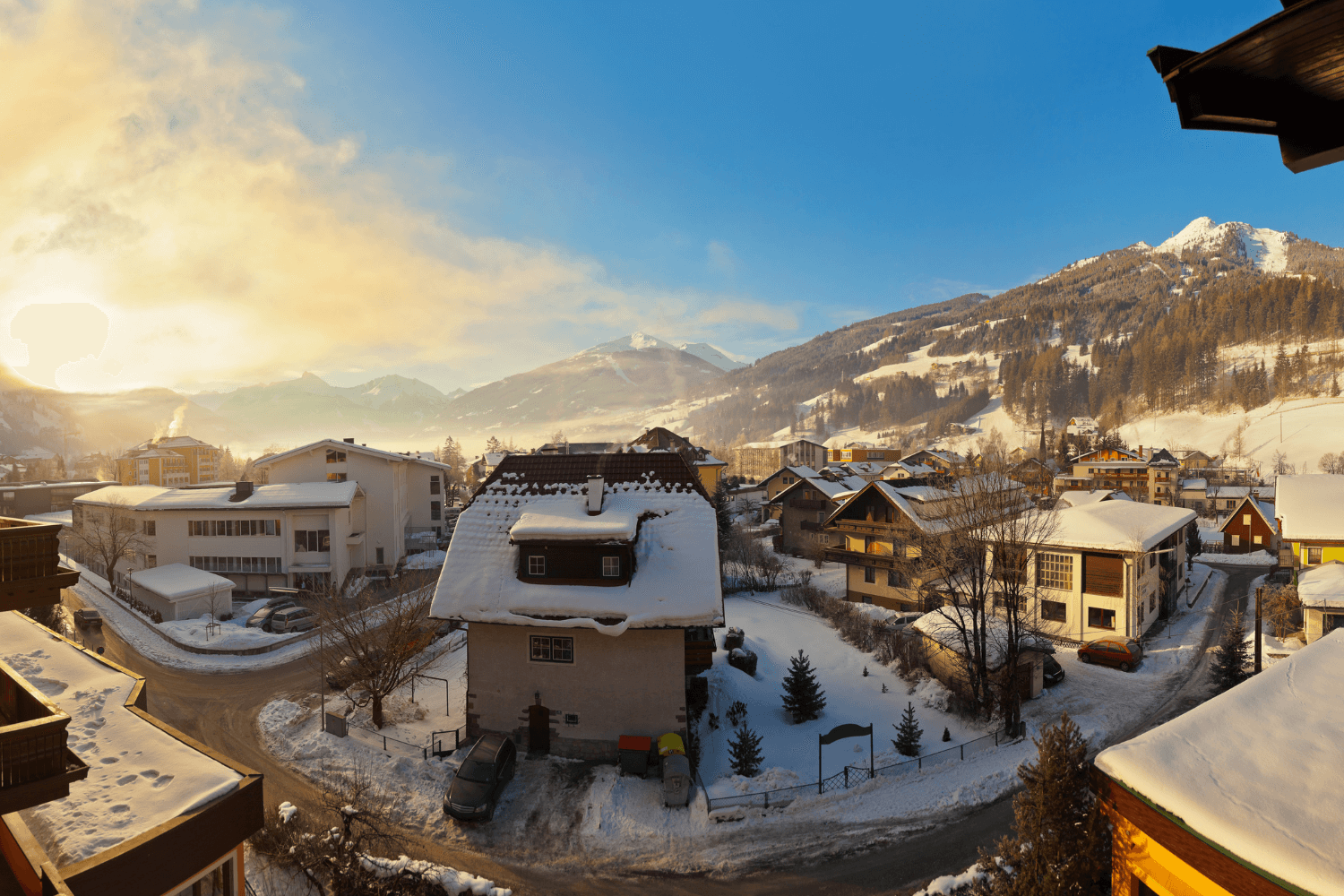 En landsby i fjellet med blå himmel og sol. Foto