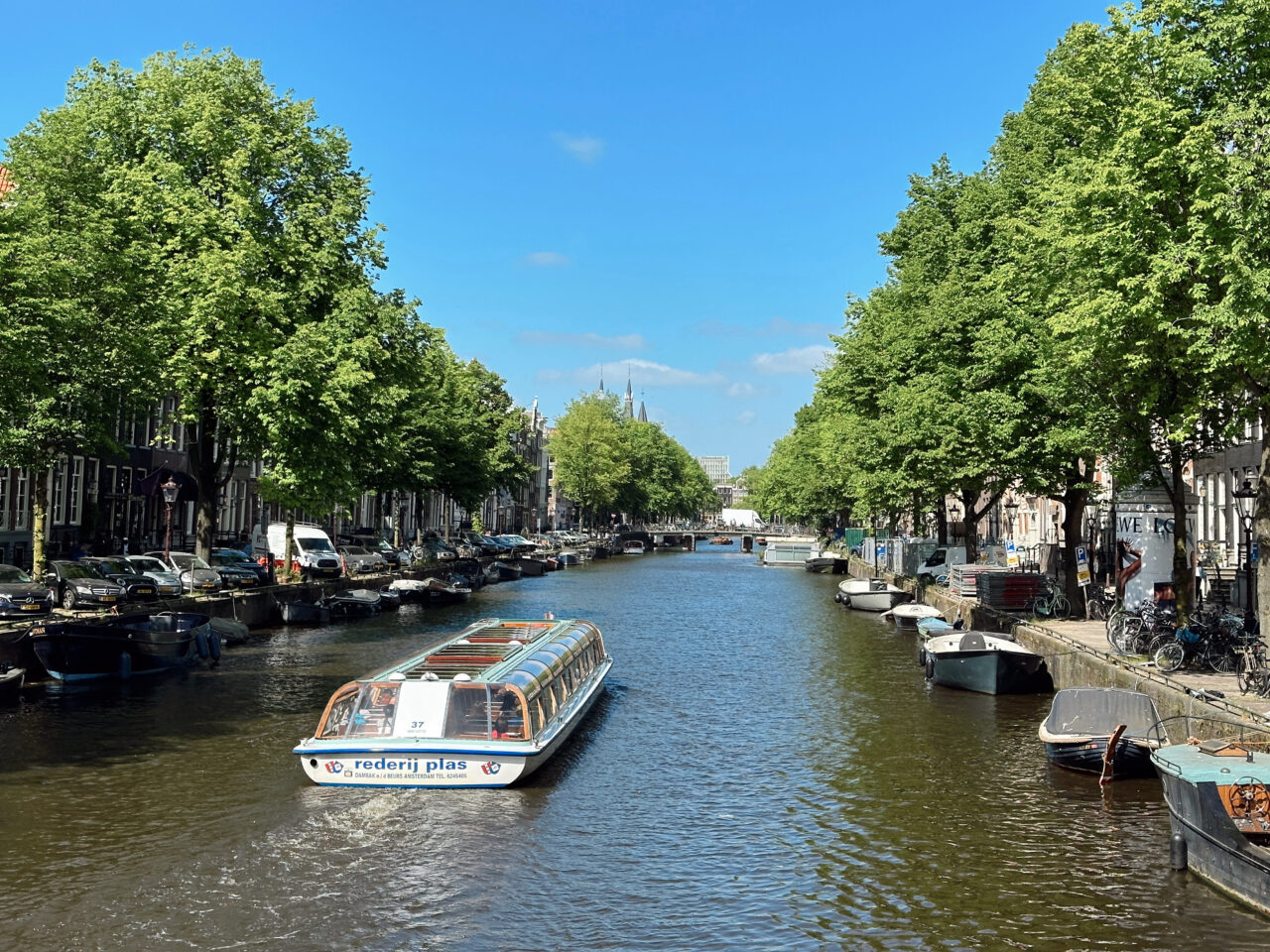 En turistbåt som glir langs en kanal i Amsterdam. Foto