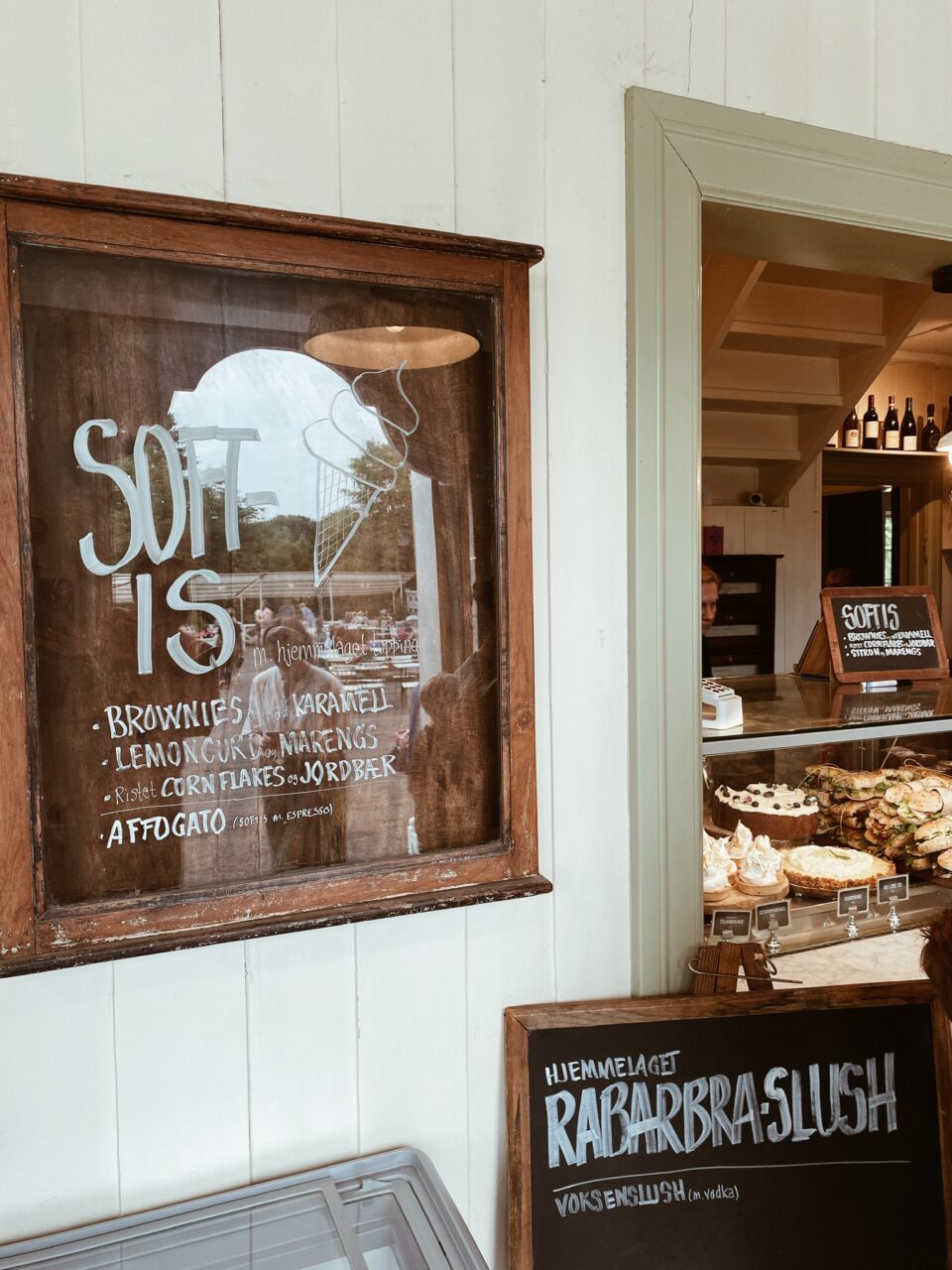 Et stort skilt hvor det står "Soft is" hengende på en vegg i en liten cafe. Foto