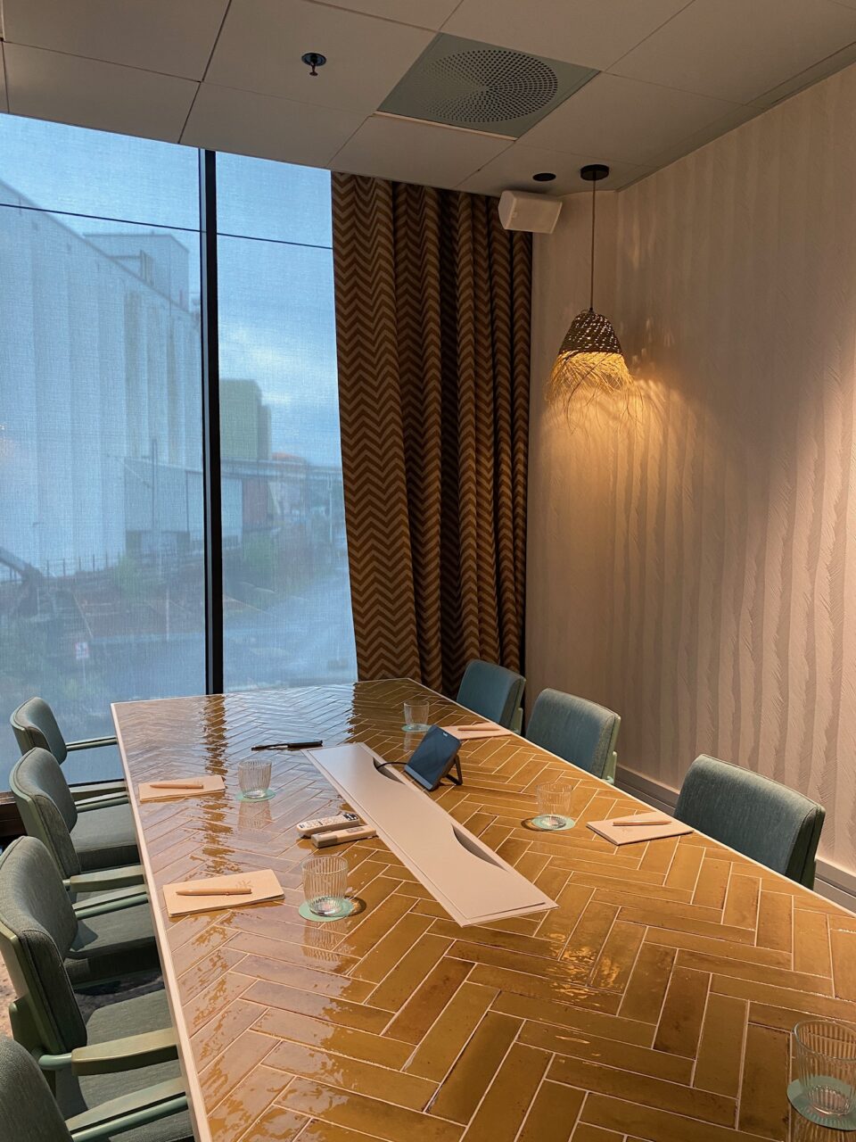 Møterom med langt bord og stoler, store vinduer og lekkert interiør. Foto