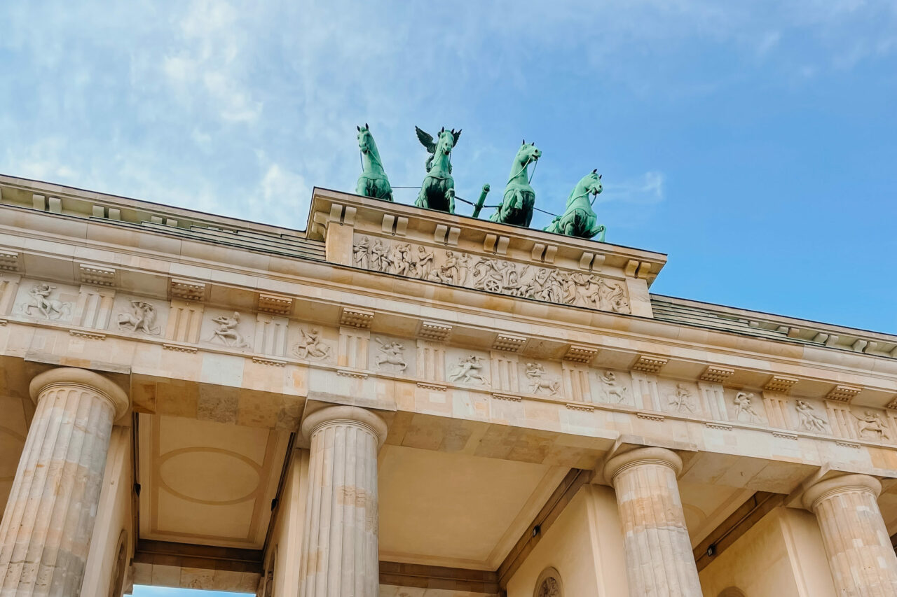 Brandenburger Tor i Berlin. Et bygg med søyler og fire hester på toppen. Foto