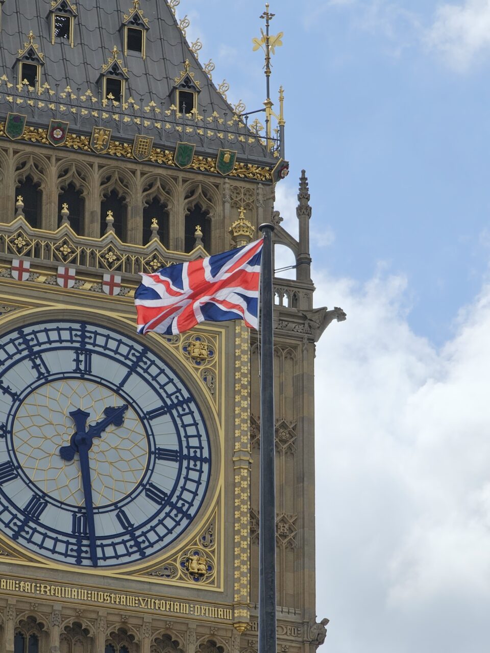 Nærbilde av en stor klokke med det britiske flagget i forkant. Foto