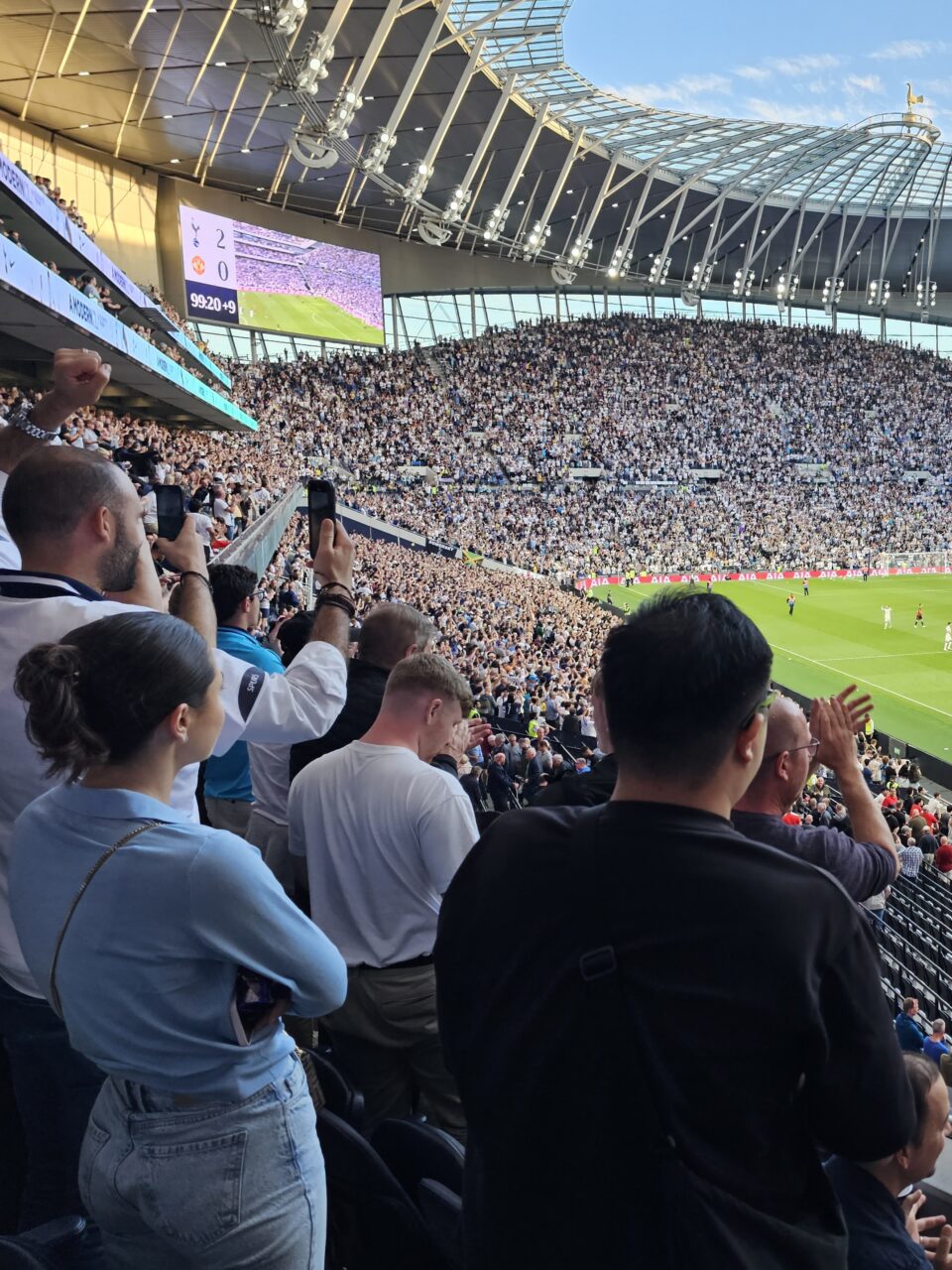 Publikum heier og ser på fotballkamp på stadion. Foto