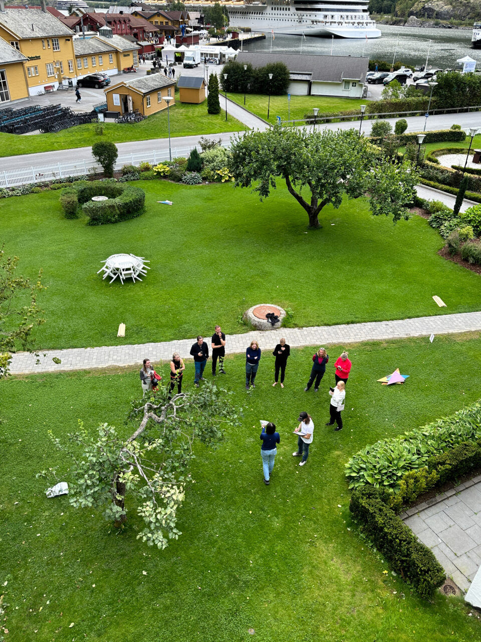 En gruppe mennesker som står i en sirkel på en gressplen. Foto