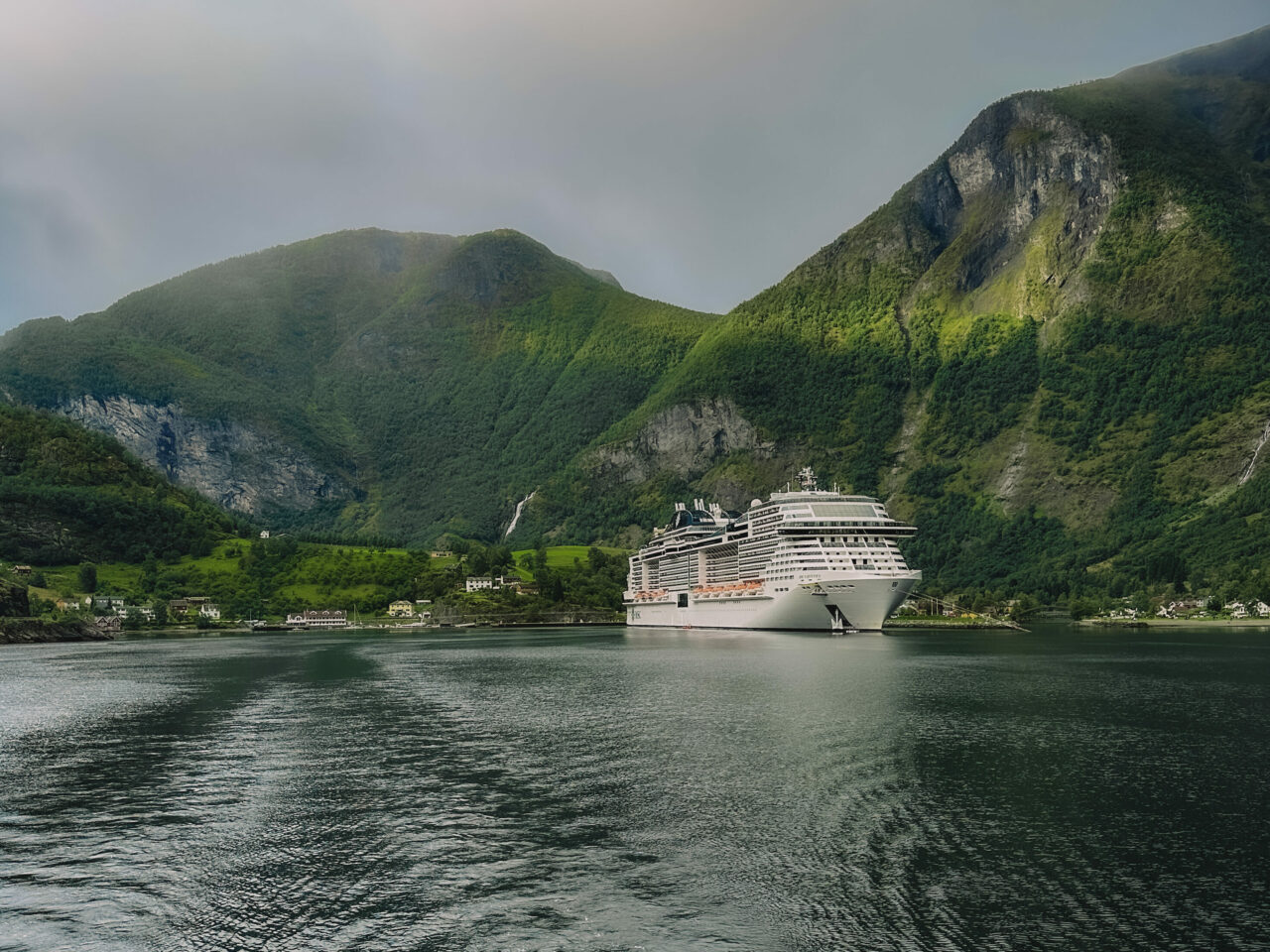 Cruiseskip ligger ankret innerst i norsk fjord. Foto