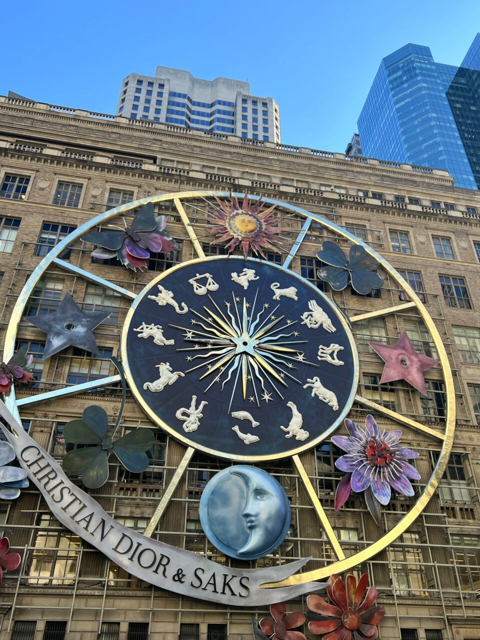 Mursteinsfasade med stort astronomisk hjul med teksten "Dior". Foto