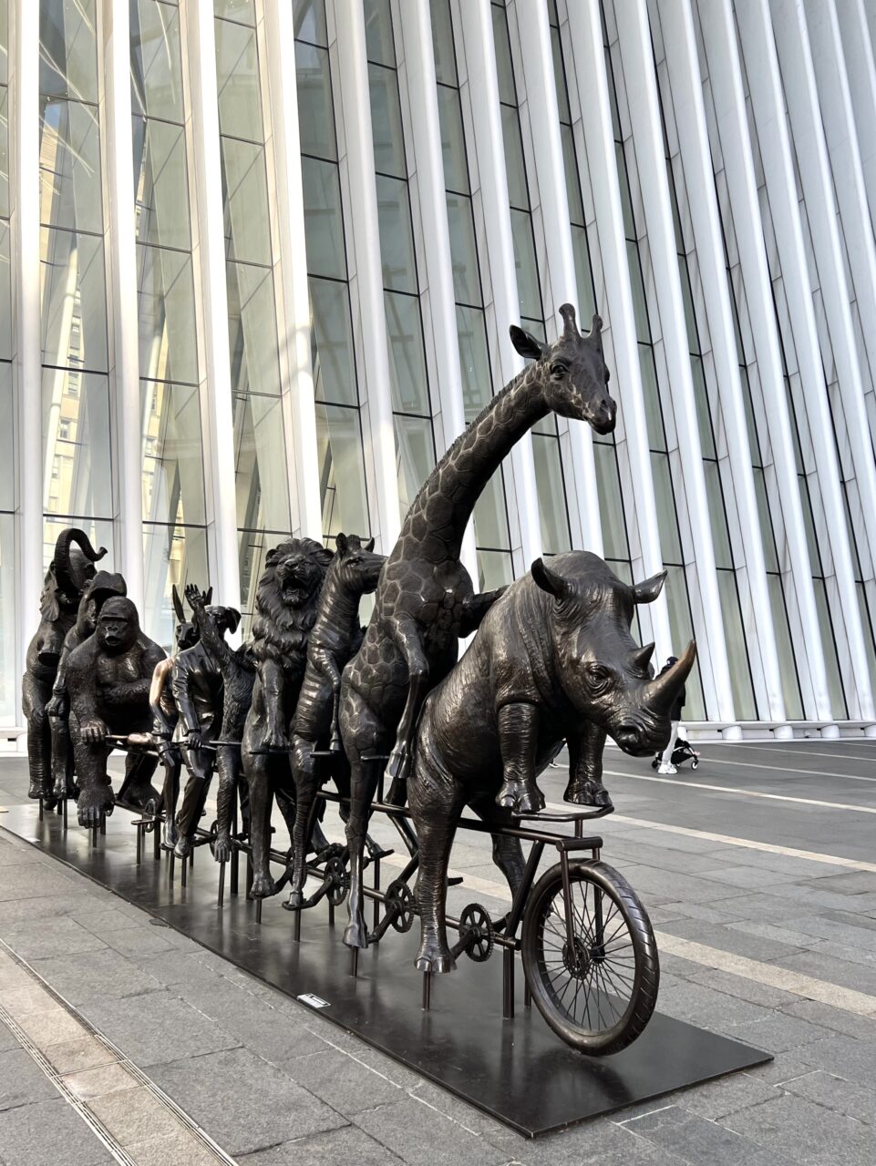 Statue laget i jern av dyr som sykler på en tandemsykkel. Foto