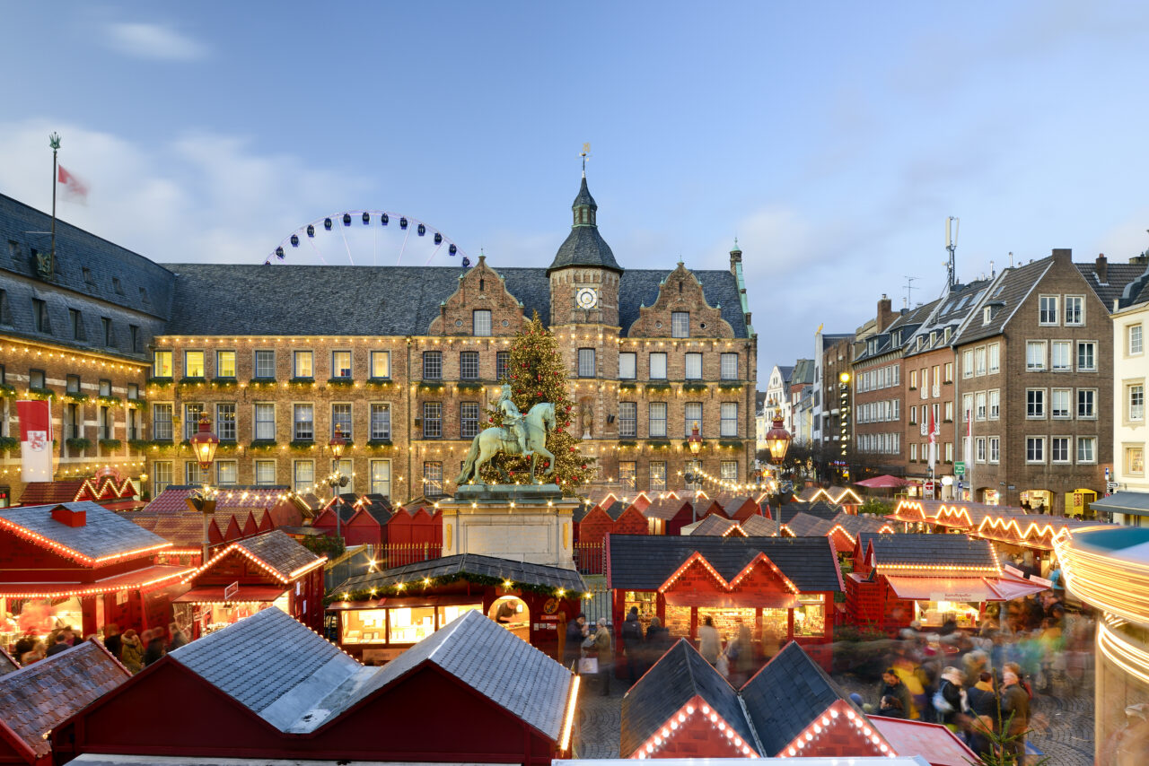 Julemarked med boder og lys på torg. Foto