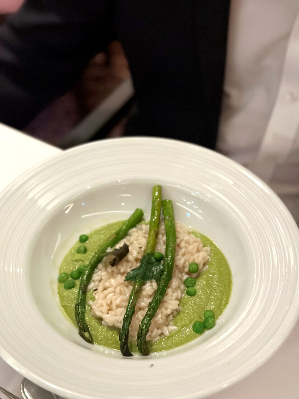 Grønn risotto på en hvit tallerken. Foto