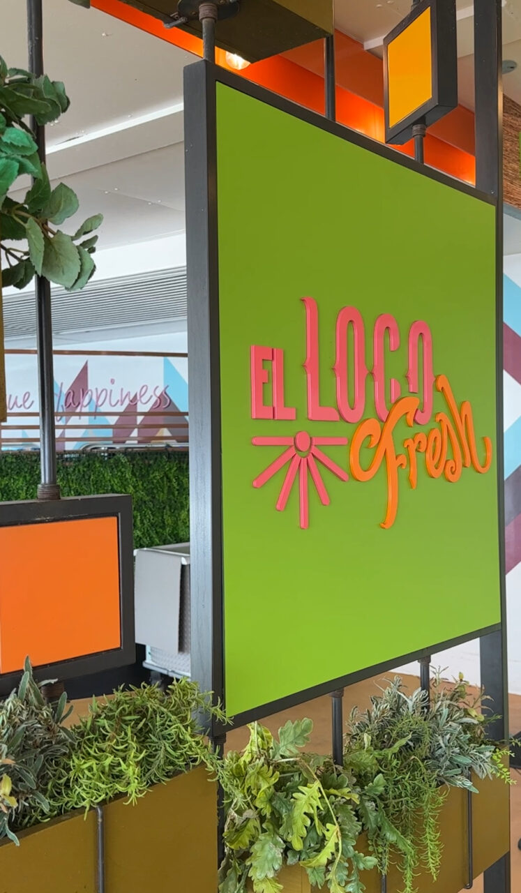 Et grønt skilt med rosa og oransje tekst hvor det står "El Loco Fresh". Foto