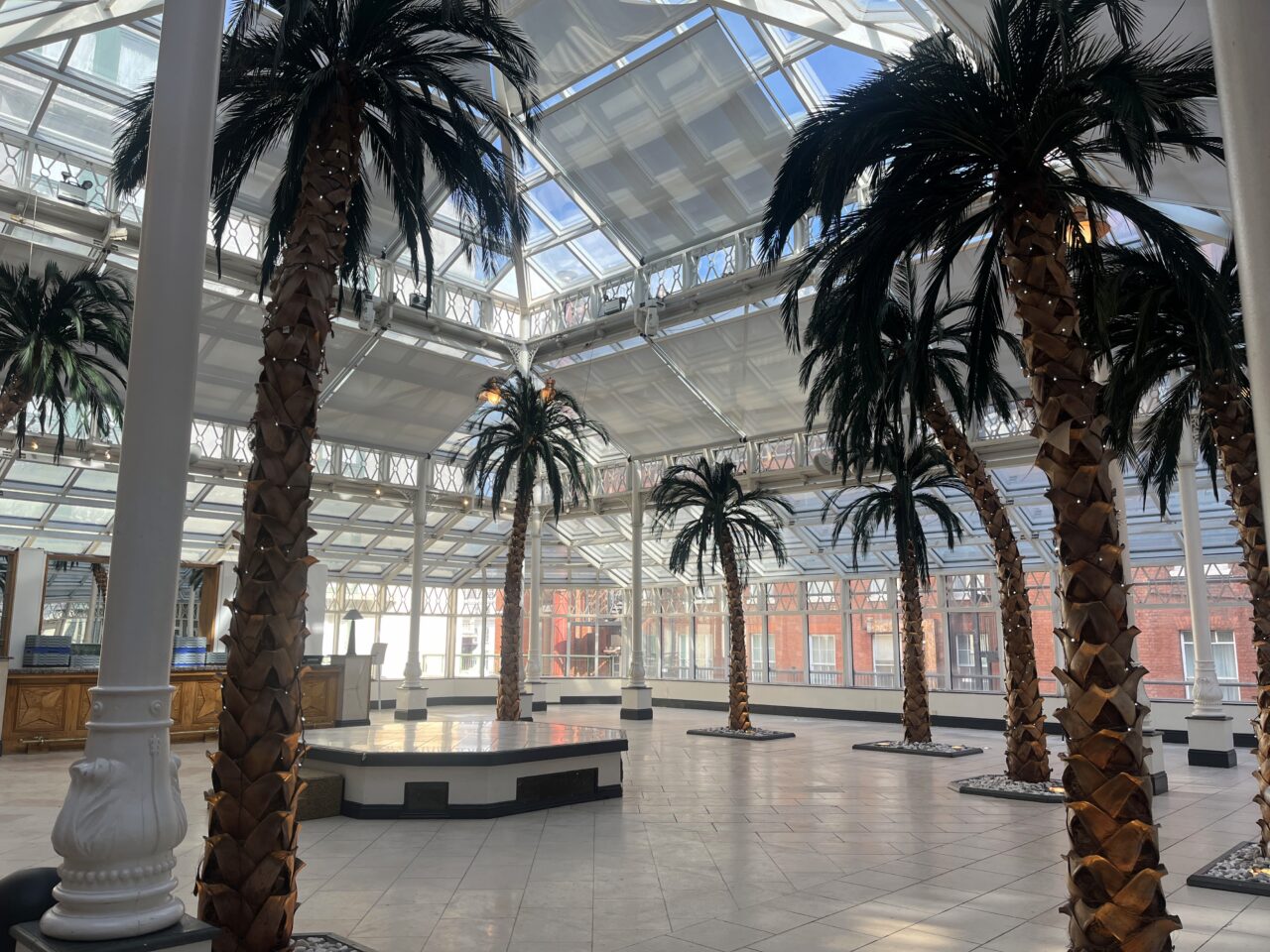 Stort glasshus med palmer som kan benyttes til eventer. Foto