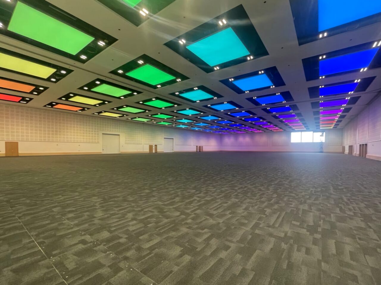 Stor konferansesal med opplyst tak i regnbuens farger. Foto
