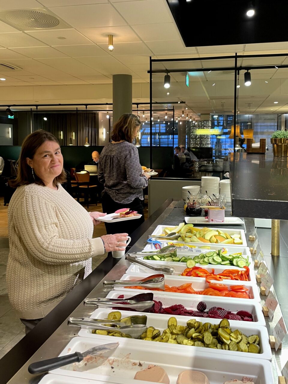 Kvinne forsyner seg av buffet. Foto