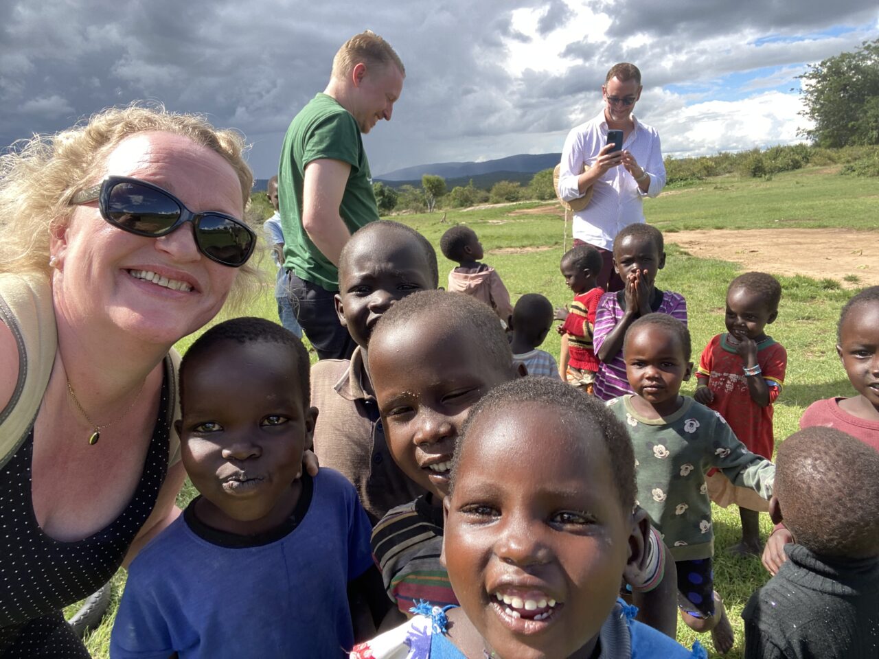 Kvinne tar selfie med mange små lokale barn. Foto