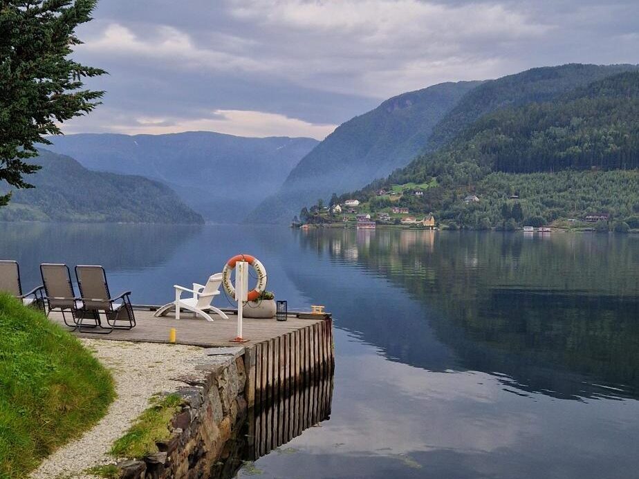 Bryggekant ved fjorden med flott utsikt. Foto