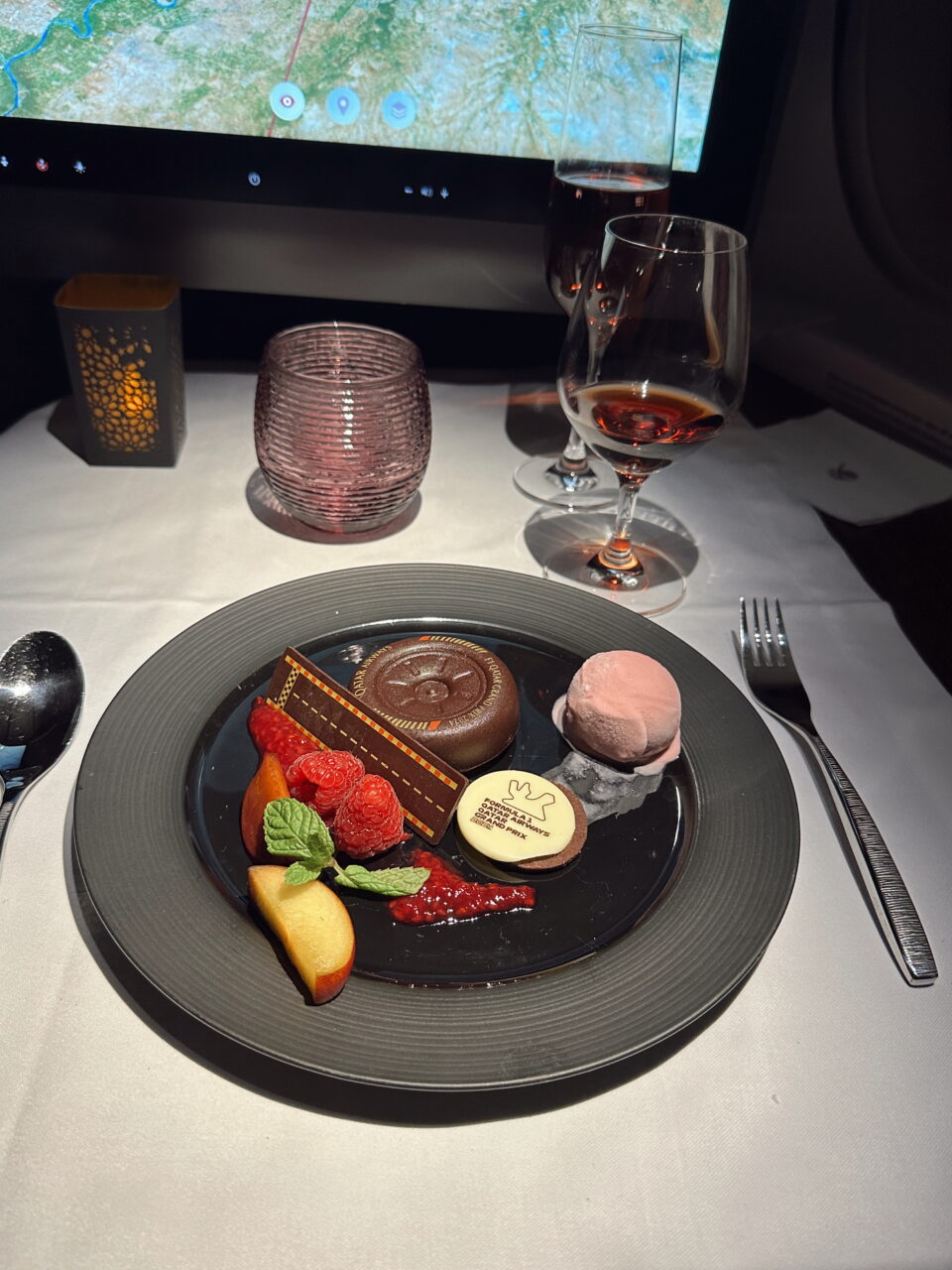 Elegant desserttallerken med glass vin og bakgrunnsskjerm. Foto